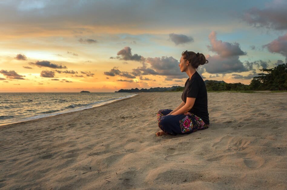 Mulher meditando na praia